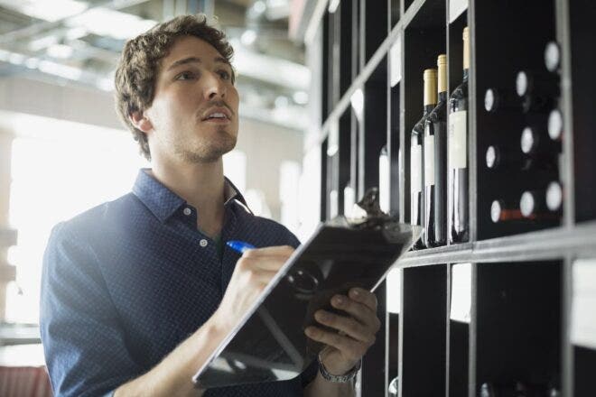 Man taking liquor inventory on clipboard