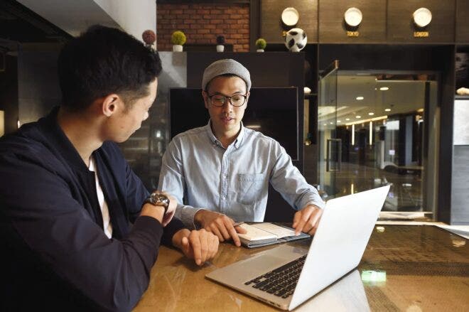Two men meeting with laptop and notebook