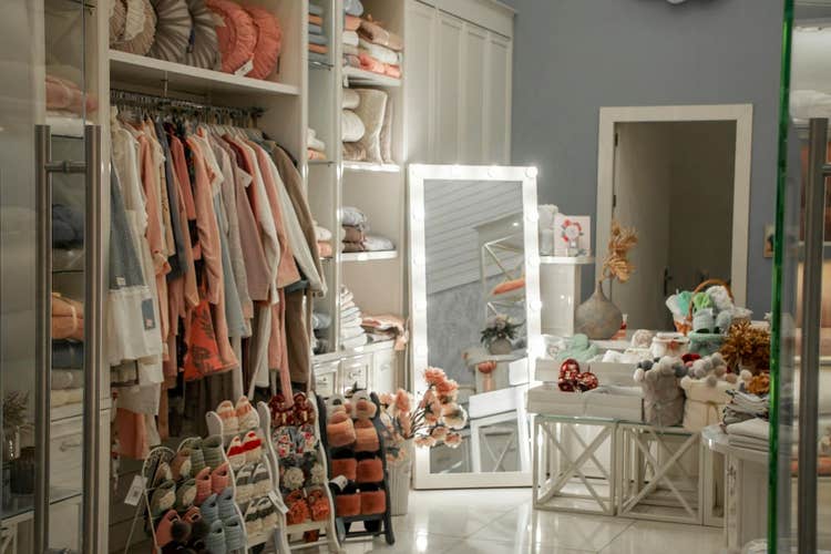 Interior view of a small boutique with clothing, shoes, and home decor