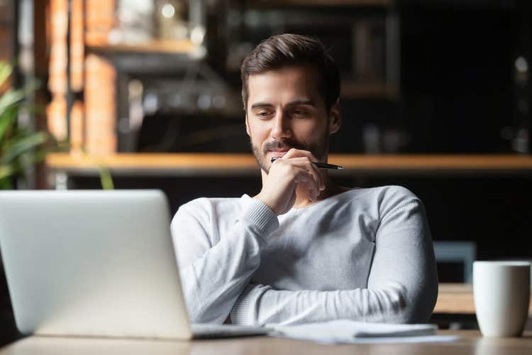 Man with pen, notepad, and laptop