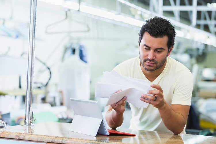 Dry cleaning business owner looking at papers