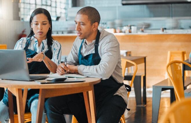 Restaurant owners looking at laptop