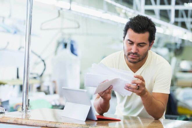 Dry cleaning business owner looking at papers