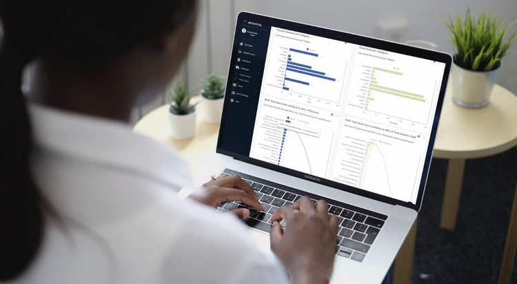 Woman looking at Analytics BusinessQ interface on laptop