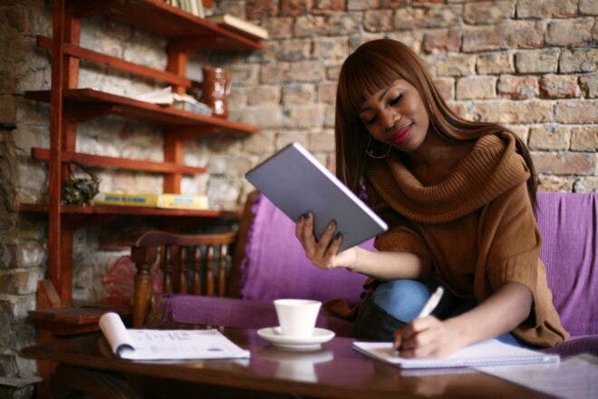 Woman holding tablet writing notes