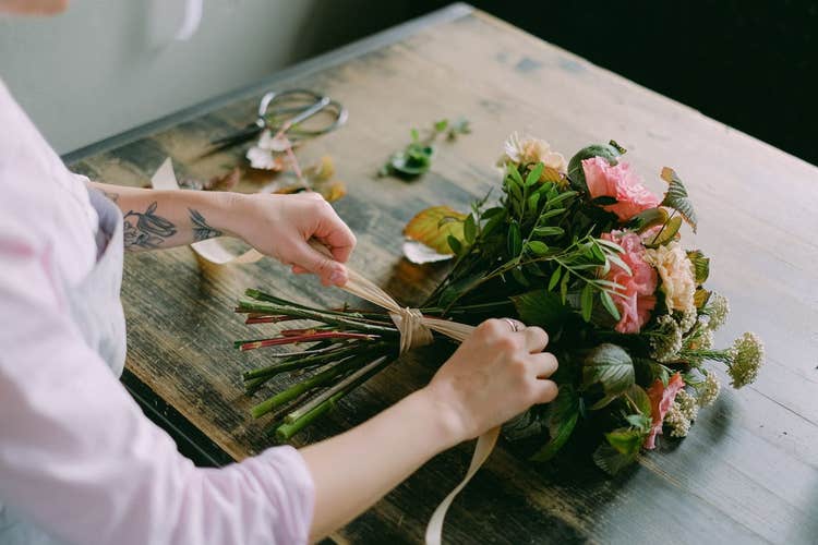 Florist tying a bouquet of flowers with a ribbon