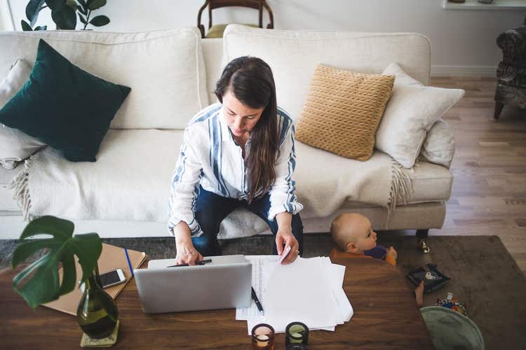 Woman business owner working with baby on the floor