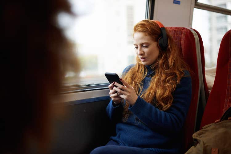Woman on train listening to headphones