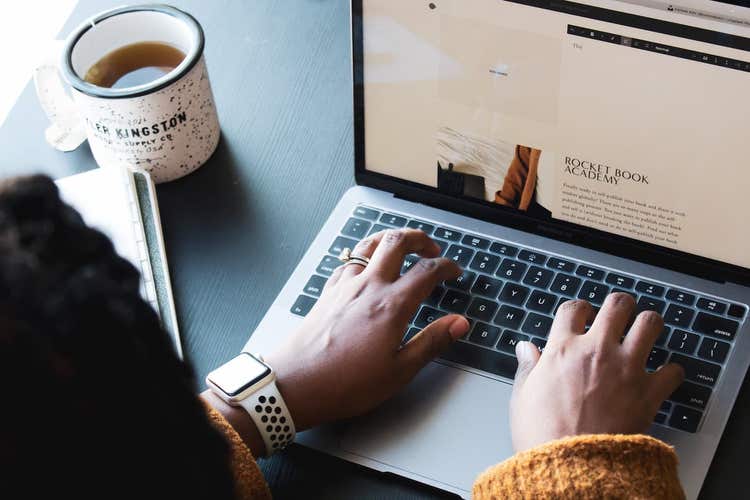 Person typing newsletter on laptop