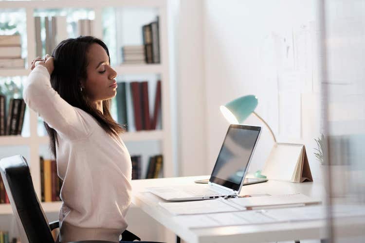 Woman stretching in front of laptop