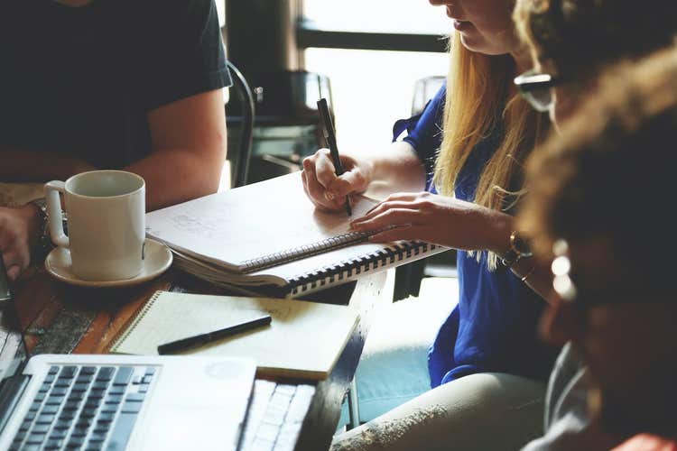 Person writing in notebook during employee training
