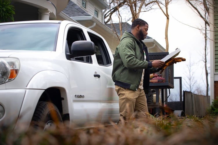 Landscaper looking at clipboard