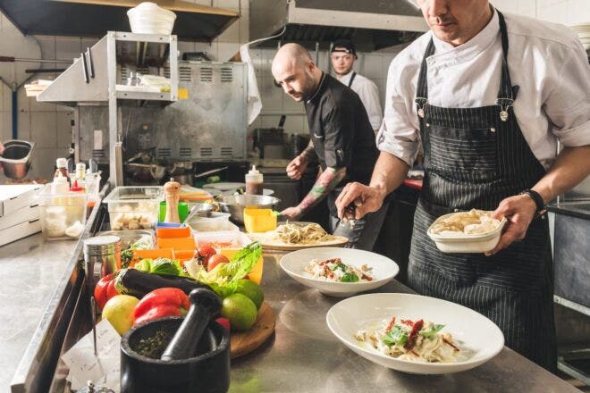 Three chefs plating entrees