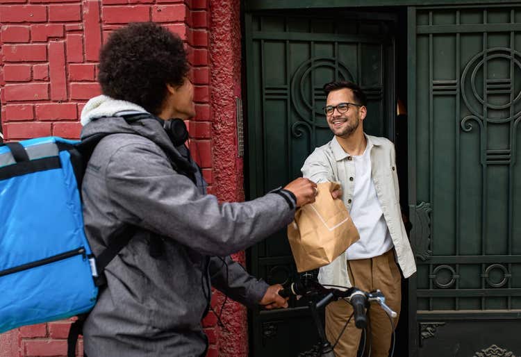 Food delivery person on bike dropping off order