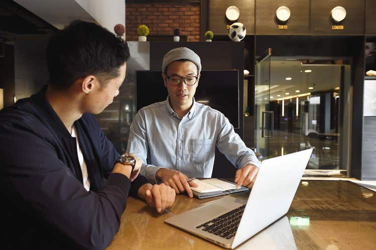 Two men meeting with laptop and notebook