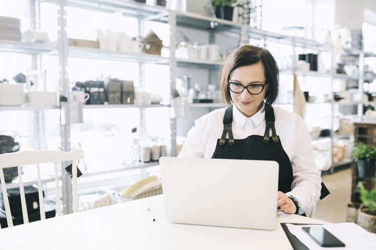 Kitchen retail store owner looking at laptop