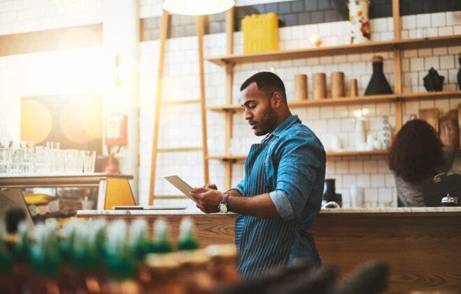 Coffee shop worker looking at tablet