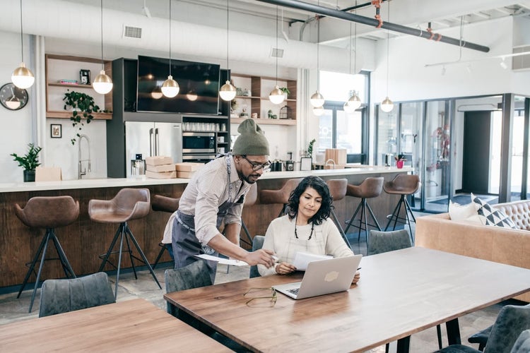 Coffee shop workers looking at laptop