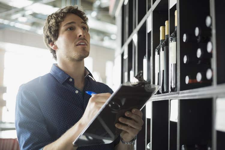 Man taking liquor inventory on clipboard