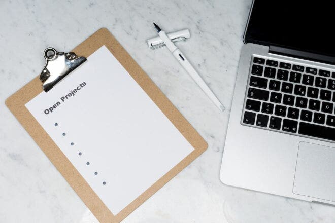 Clipboard next to a laptop