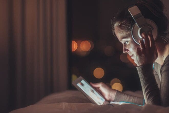 Woman wearing headphones watching tablet