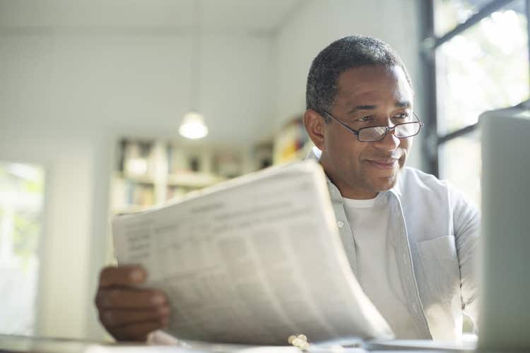Man looking at computer screen holding papers