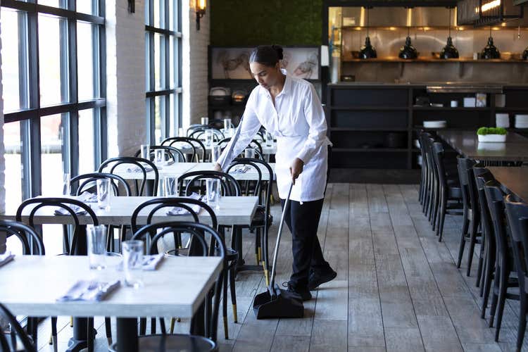 Waitress sweeping in restaurant