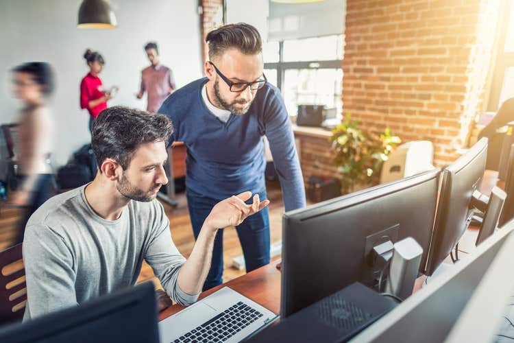 Two male coworkers looking at computer screens