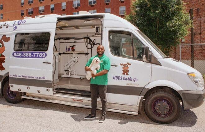 Man with dog in front of mobile grooming van