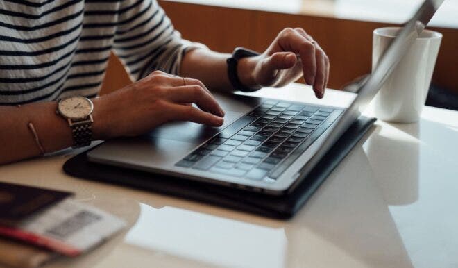 Hands typing on a laptop keyboard