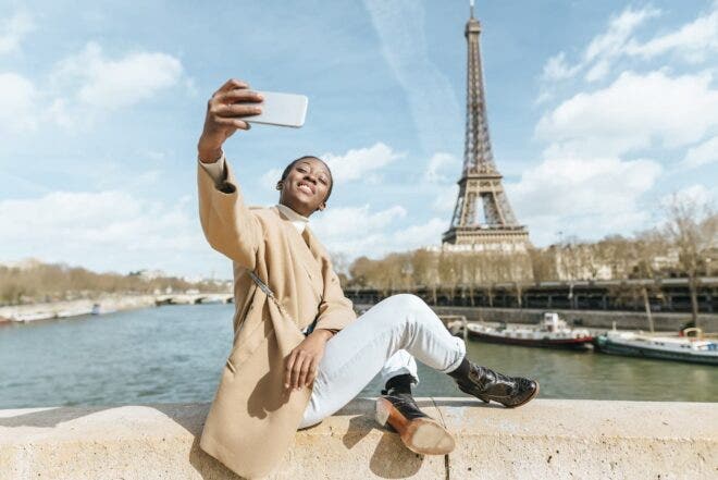 Woman taking selfie in front of Eiffel Tower
