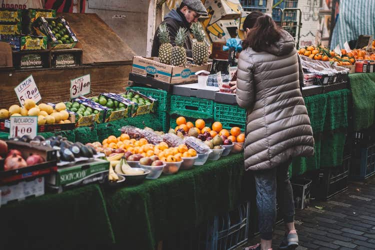 Woman buying produce at farmers market stand