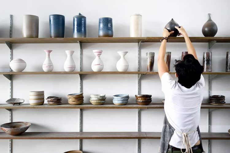 Store owner stocking pottery