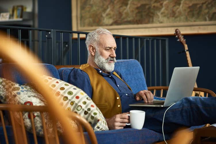 Man sitting on sofa looking at laptop
