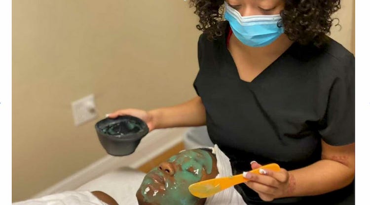 Cosmetology student giving a client a facial