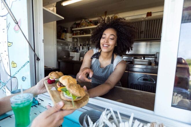 Food stand worker with tray of burgers