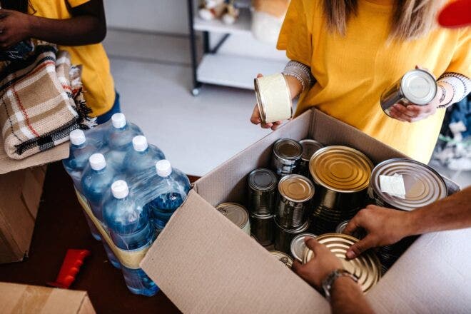 Packing donation boxes with canned goods, bottled water, blankets