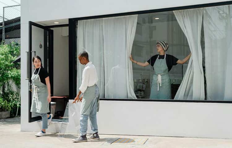 Restaurant staff working on exterior of restaurant to open it