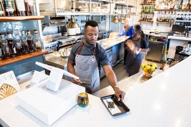 Restaurant server closing out check at POS