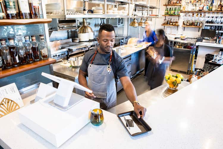 Restaurant server closing out check at POS
