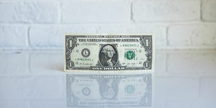 One dollar bill on top of a counter