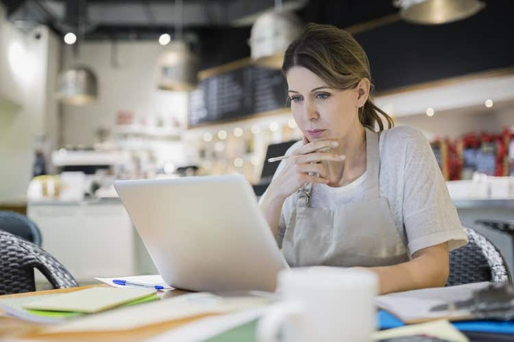 Restaurant owner looking at laptop