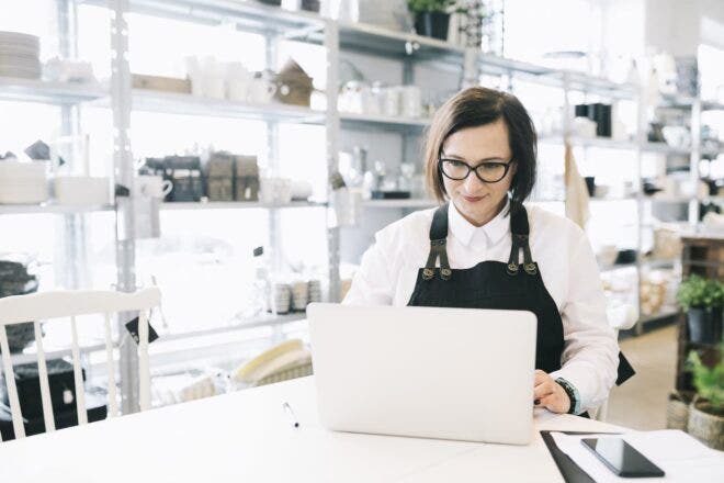 Kitchen retail store owner looking at laptop