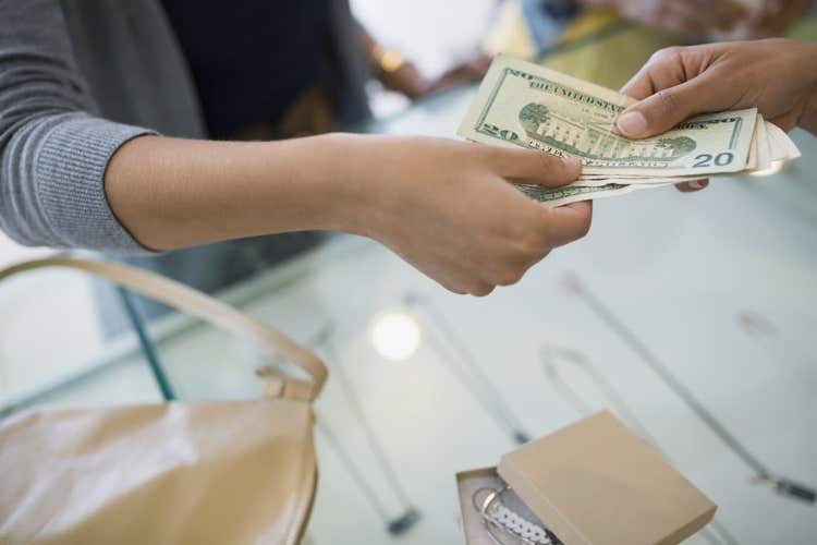 Person paying cash for jewelry
