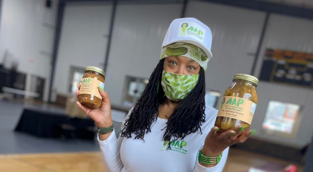 Aliska Walker holding two jars of her pickles