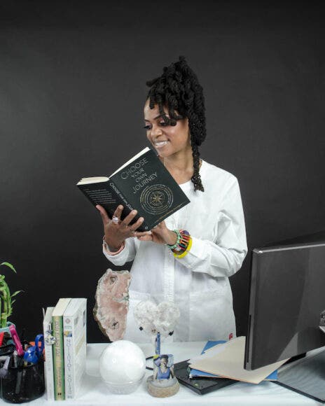 Owner of Sacred Waters Wellness Arts Studio reading a book