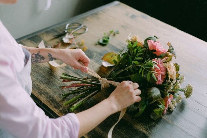 Florist tying a bouquet of flowers with a ribbon