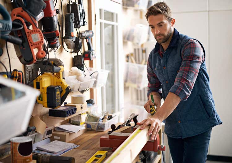 Carpenter measuring wood on a workbench