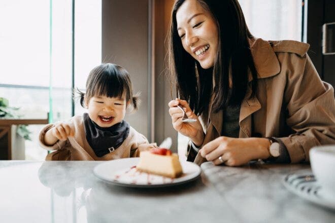 mother and child eating cheesecake at restaurant