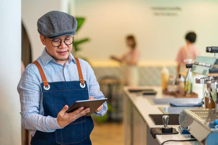 Barista man looking at tablet